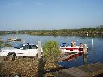 boat ready to be launched on glassy river, 2 guys in boat