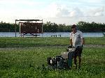 man with lawn mower mowing the ski site w/ river in background